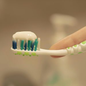 a person is holding a toothbrush with toothpaste on it